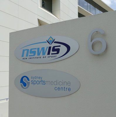 Location sign showing NSWIS logo above Sydney Sports Medicine Centre logo and the number 6